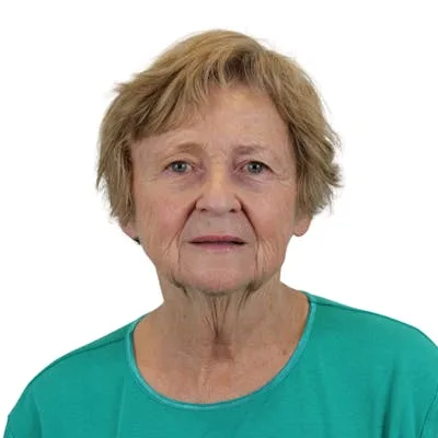 A woman in a teal top with a neutral expression.