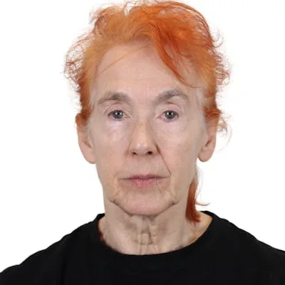 A woman with orange hair in a black shirt.