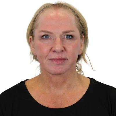 A woman with blonde hair and fair skin looking at the camera.