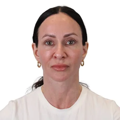 A woman in a white top with long dark hair.