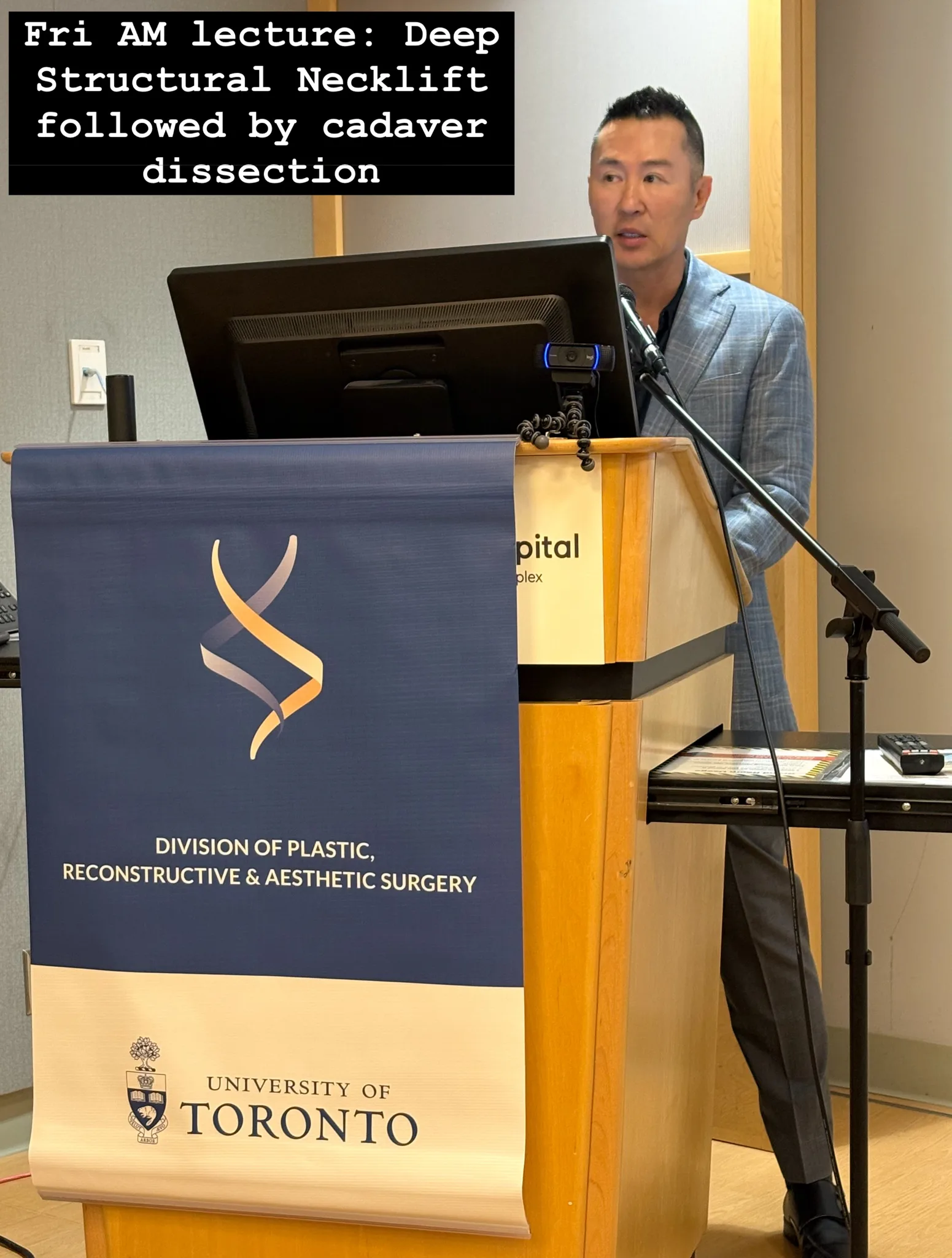 A speaker presenting at a plastic surgery lecture.