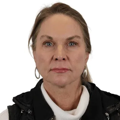 A woman with light brown hair and hoop earrings.