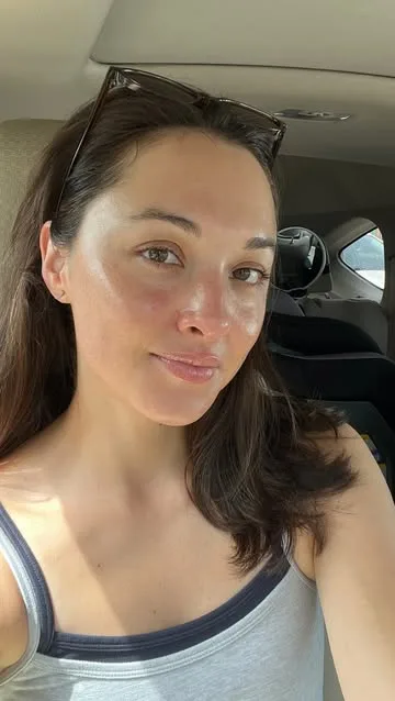 A woman with smooth skin sitting in a car.