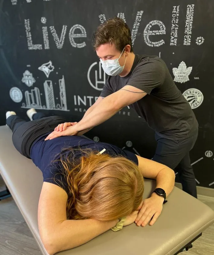 A therapist giving a massage to a woman on a table.