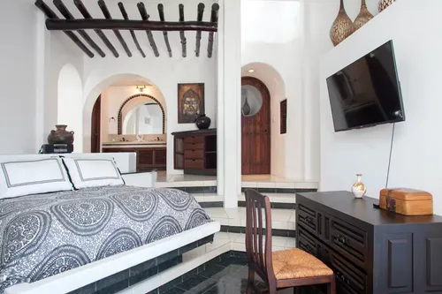 Luxurious bedroom with decorative elements and a flat-screen TV.