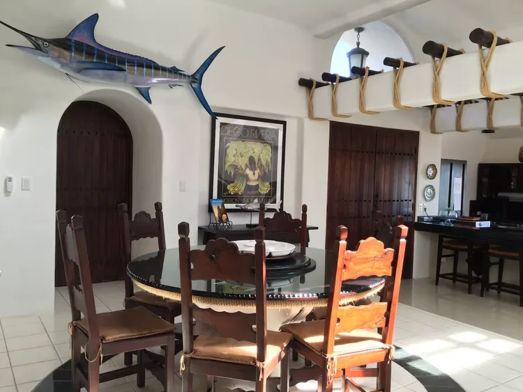 A dining area with a mounted marlin and fishing rods.