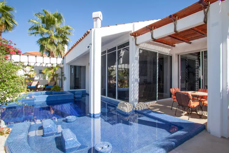 A luxury villa with an infinity pool and tropical plants.