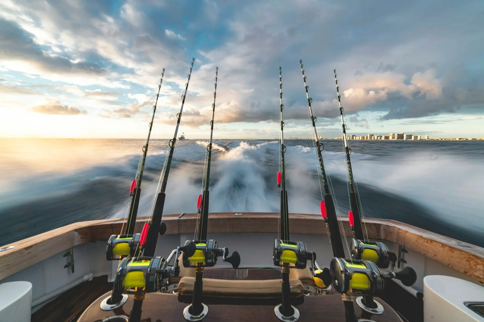 Fishing rods on a boat speeding through the ocean.