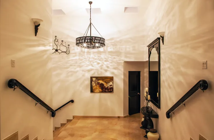 Elegant staircase with chandelier and decorative elements.