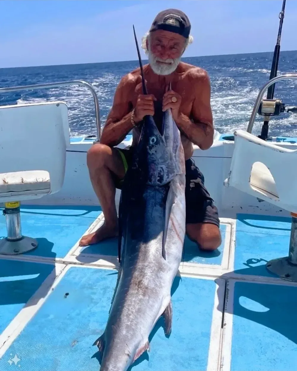 A man proudly holding a large fish on a boat.