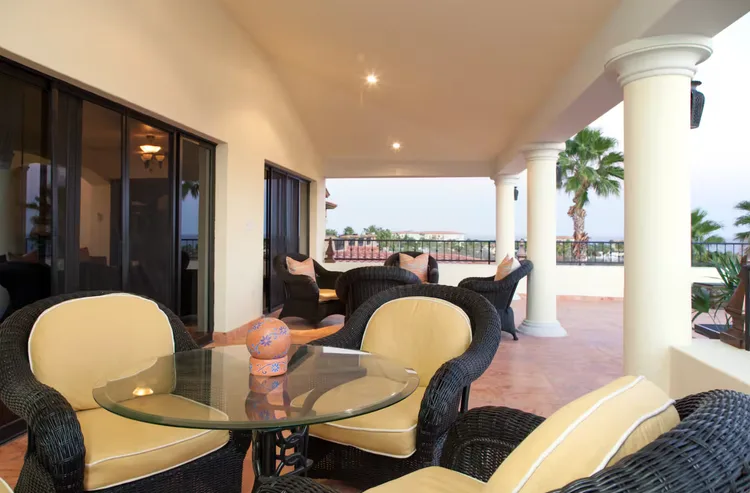A patio with wicker furniture and a distant view.