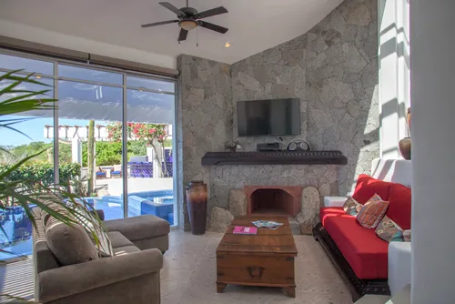 Cozy living room with red sofa and pool view.