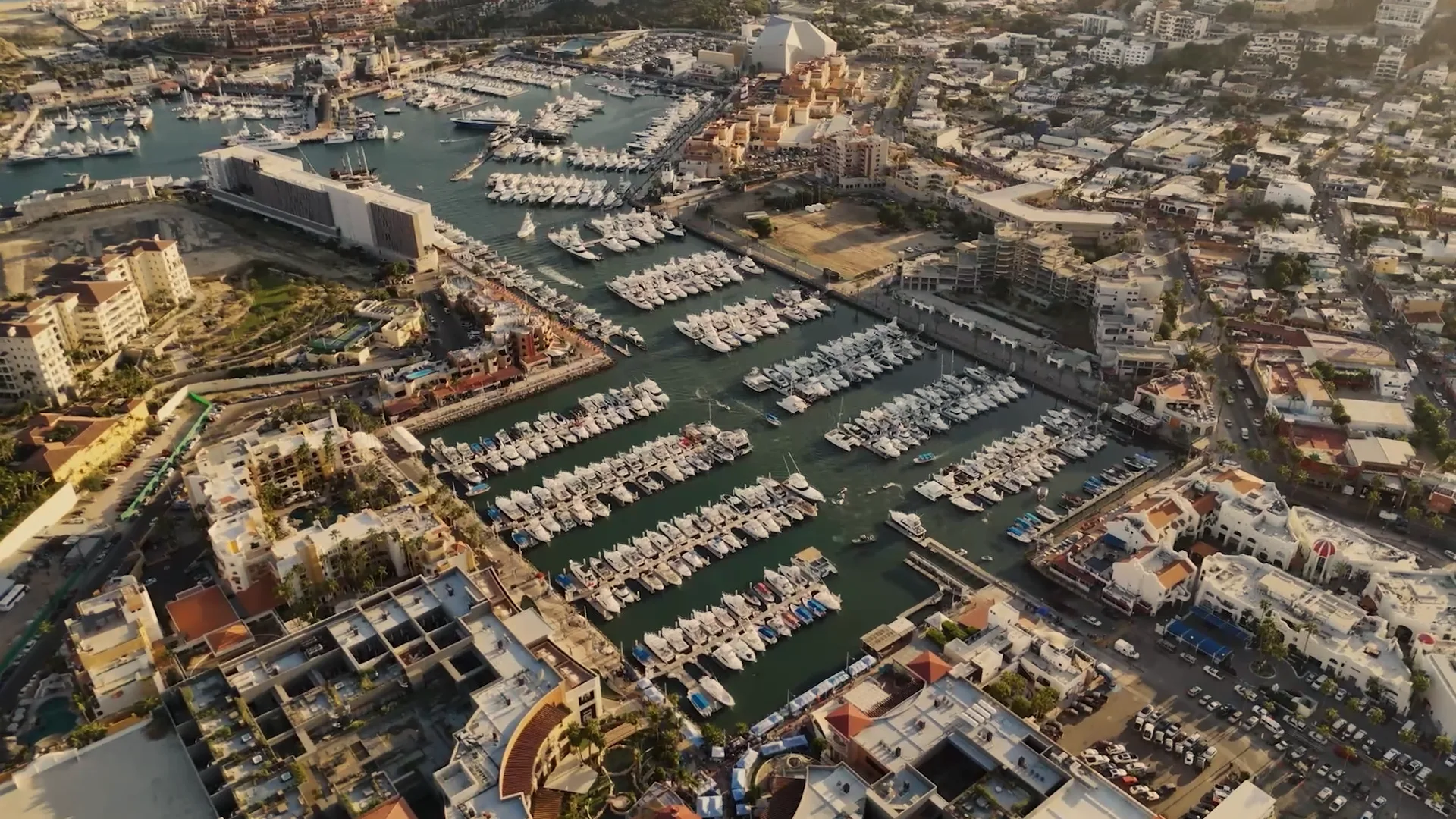 Aerial view of a marina with many boats and modern buildings.