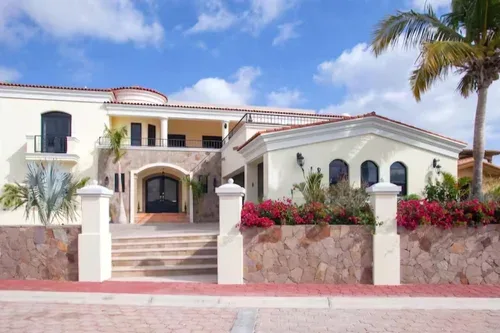 Luxurious villa with stone accents and tropical landscaping.