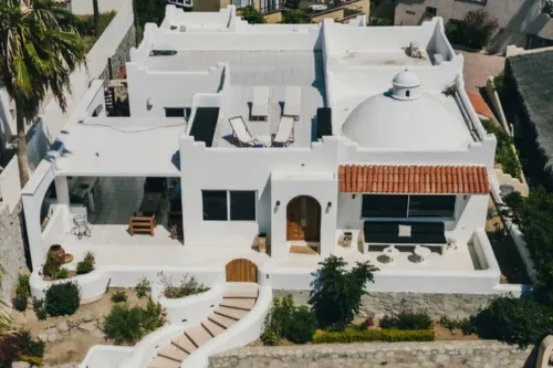 Aerial view of a white villa with a domed roof and terrace.