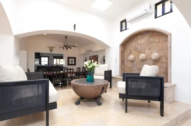 Stylish seating area with wicker chairs and decorative stone wall.