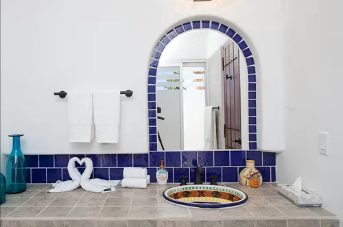 Luxurious bathroom with blue tiles and heart-shaped towels.