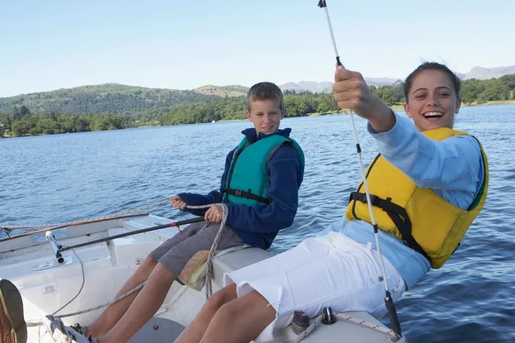 Two kids in a boat enjoying a day on the lake.