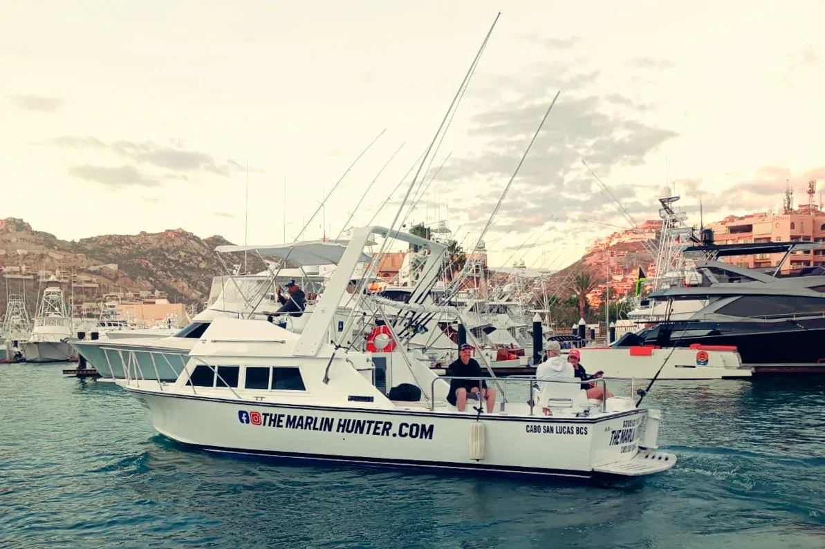 A fishing boat named The Marlin Hunter in a marina.