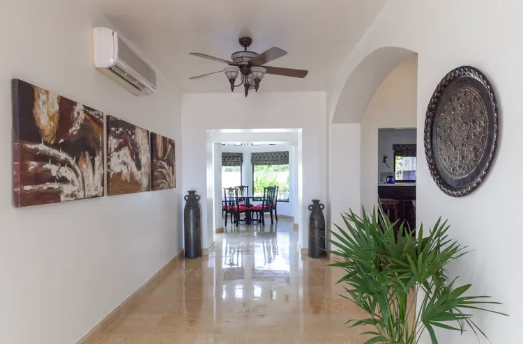 A spacious hallway with vases and abstract art.