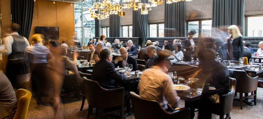 A busy restaurant interior with diners and waitstaff.