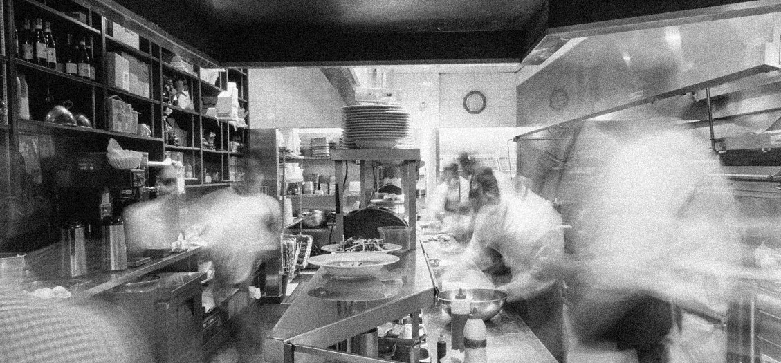 Busy restaurant kitchen with chefs at work.