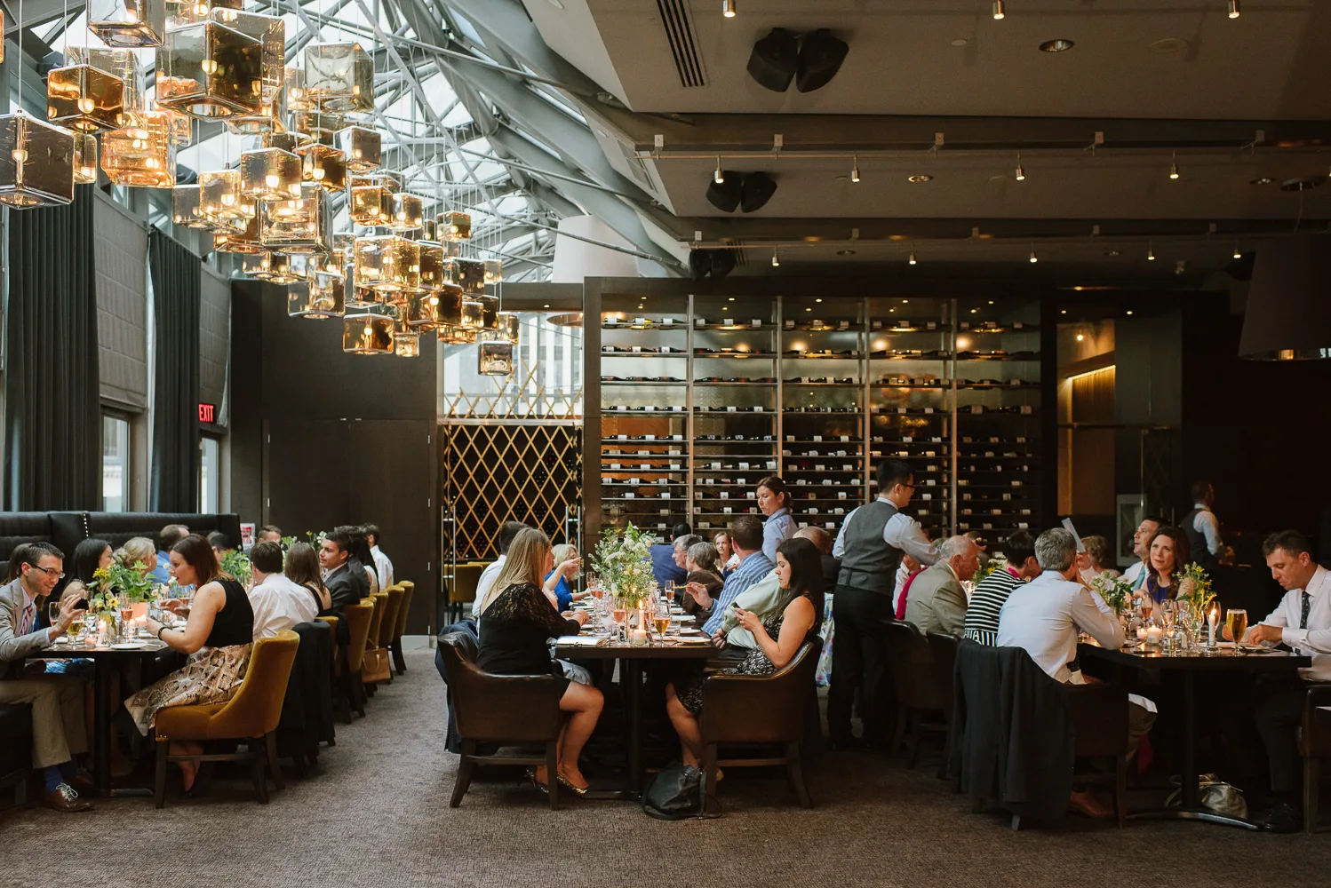 A bustling restaurant interior with guests dining and modern decor.