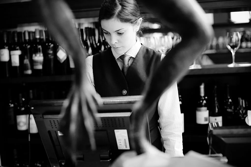 Staff member operating a point-of-sale terminal in a restaurant.
