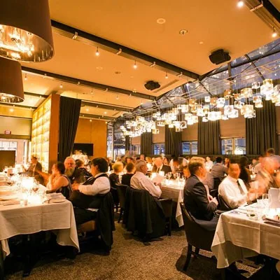 A lively restaurant interior with tables and pendant lights.