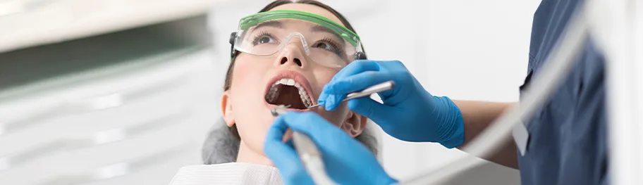 A dental professional examining a patient's teeth in a clinic