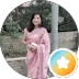 A woman in a pink saree standing outdoors.