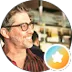 A man smiling in a café setting.