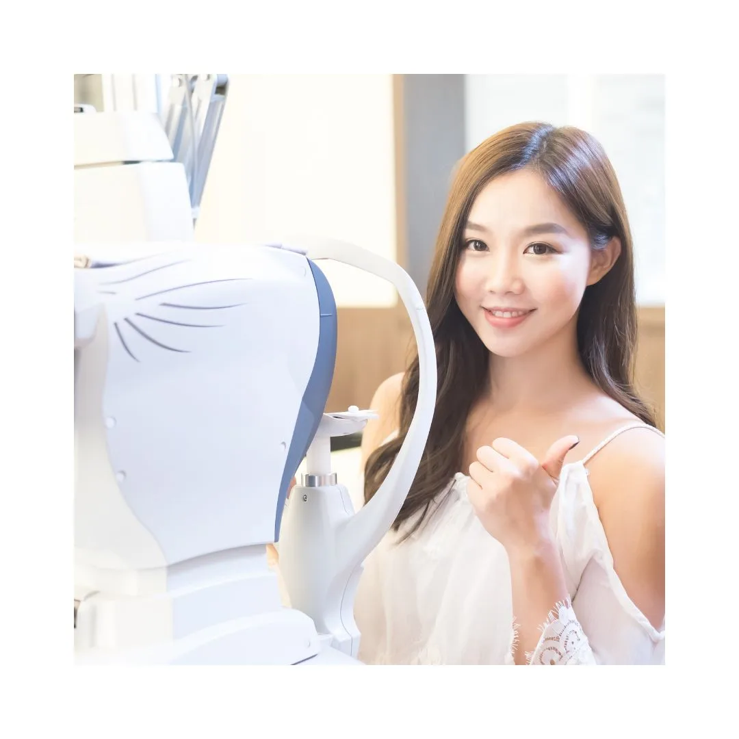 A woman giving a thumbs up next to an optometry machine.