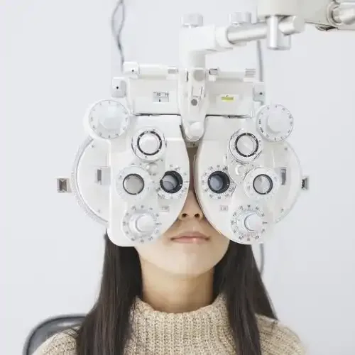 A patient receiving a comprehensive eye exam with a phoropter.