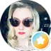 A woman with sunglasses and red lipstick poses for a photo.