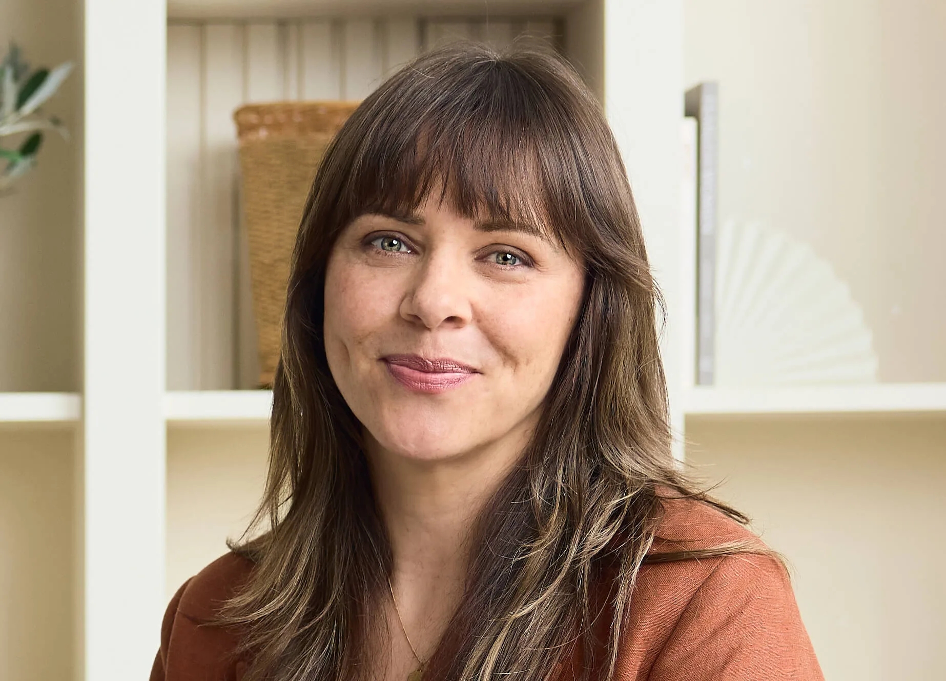 A woman smiling in a bright interior setting