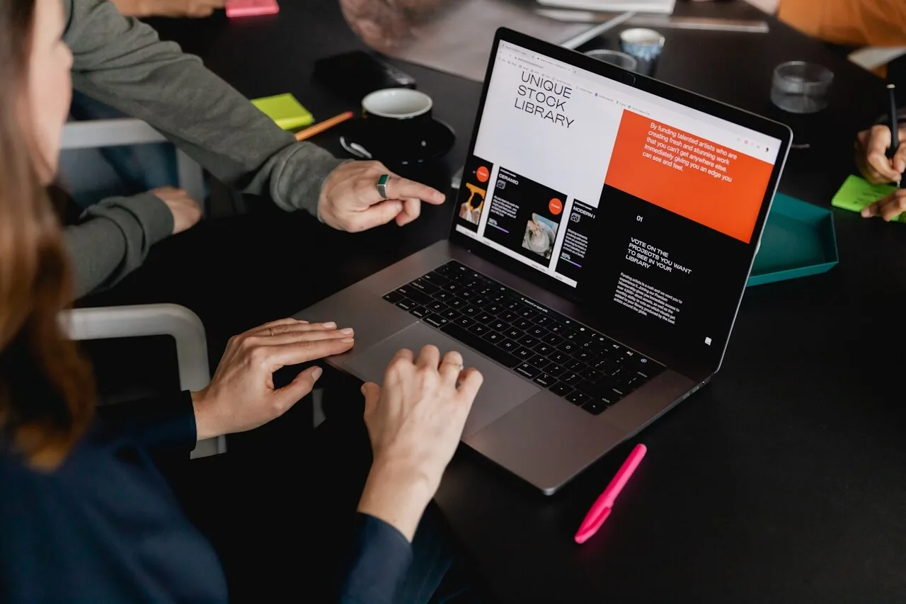 A person interacting with a laptop in a collaborative setting.