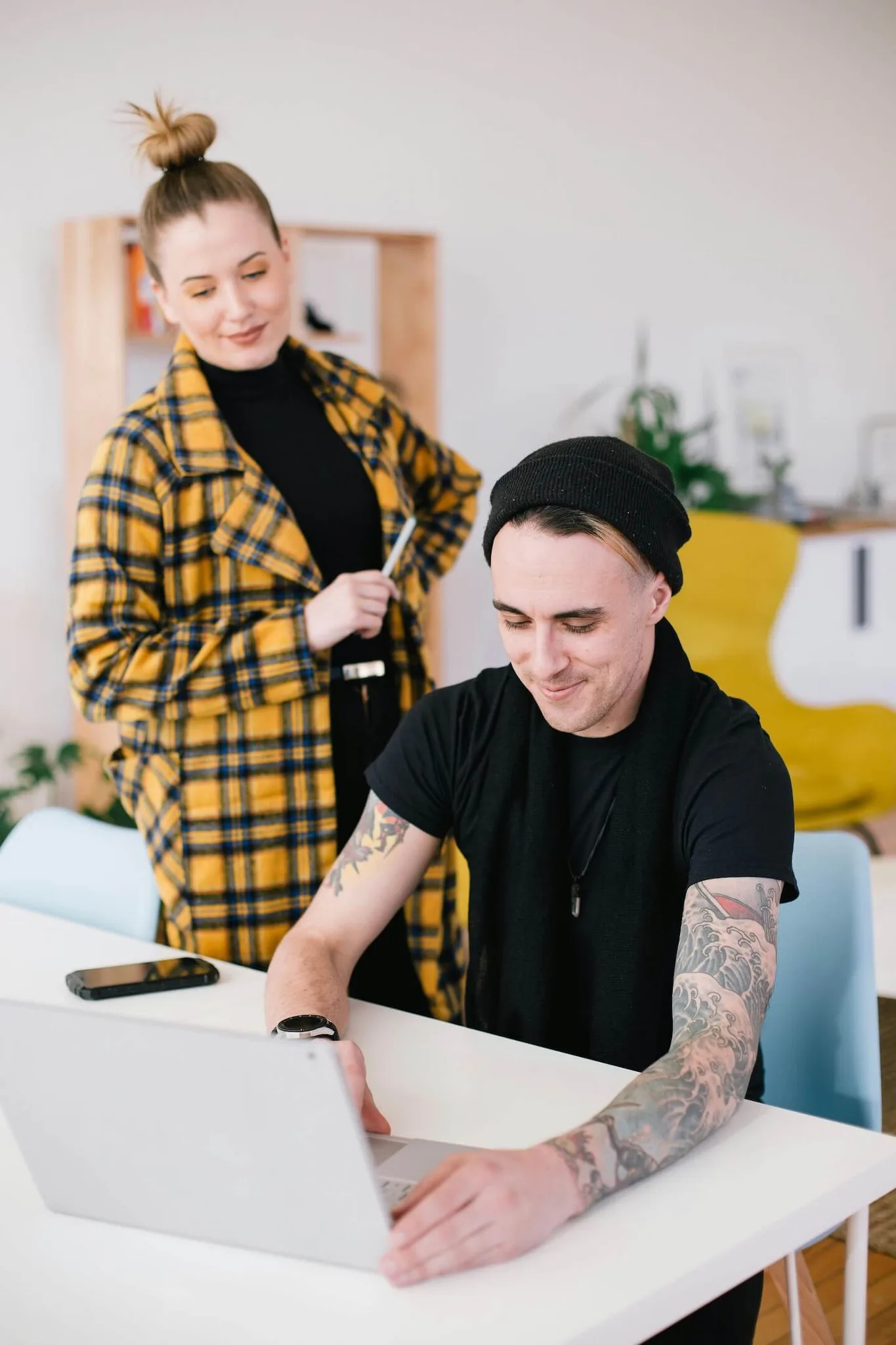 A man and woman collaborating in a bright workspace.