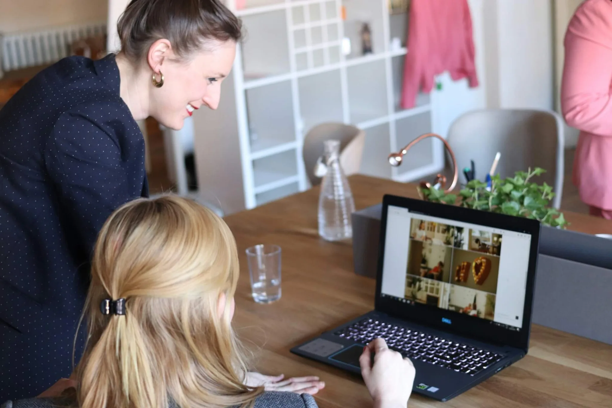 Two women collaboratively discussing content on a laptop.