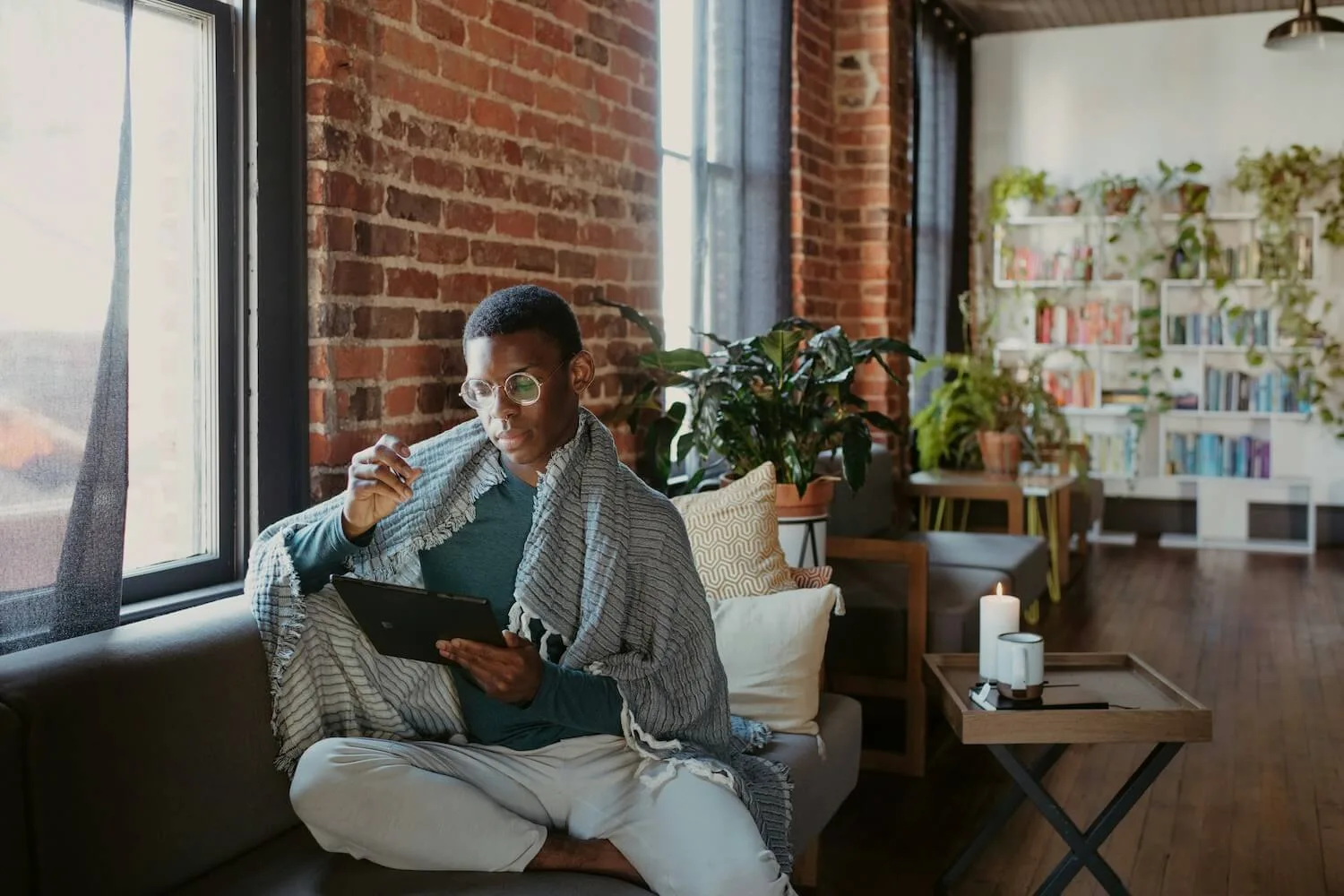 A man working on a tablet in a cozy room.