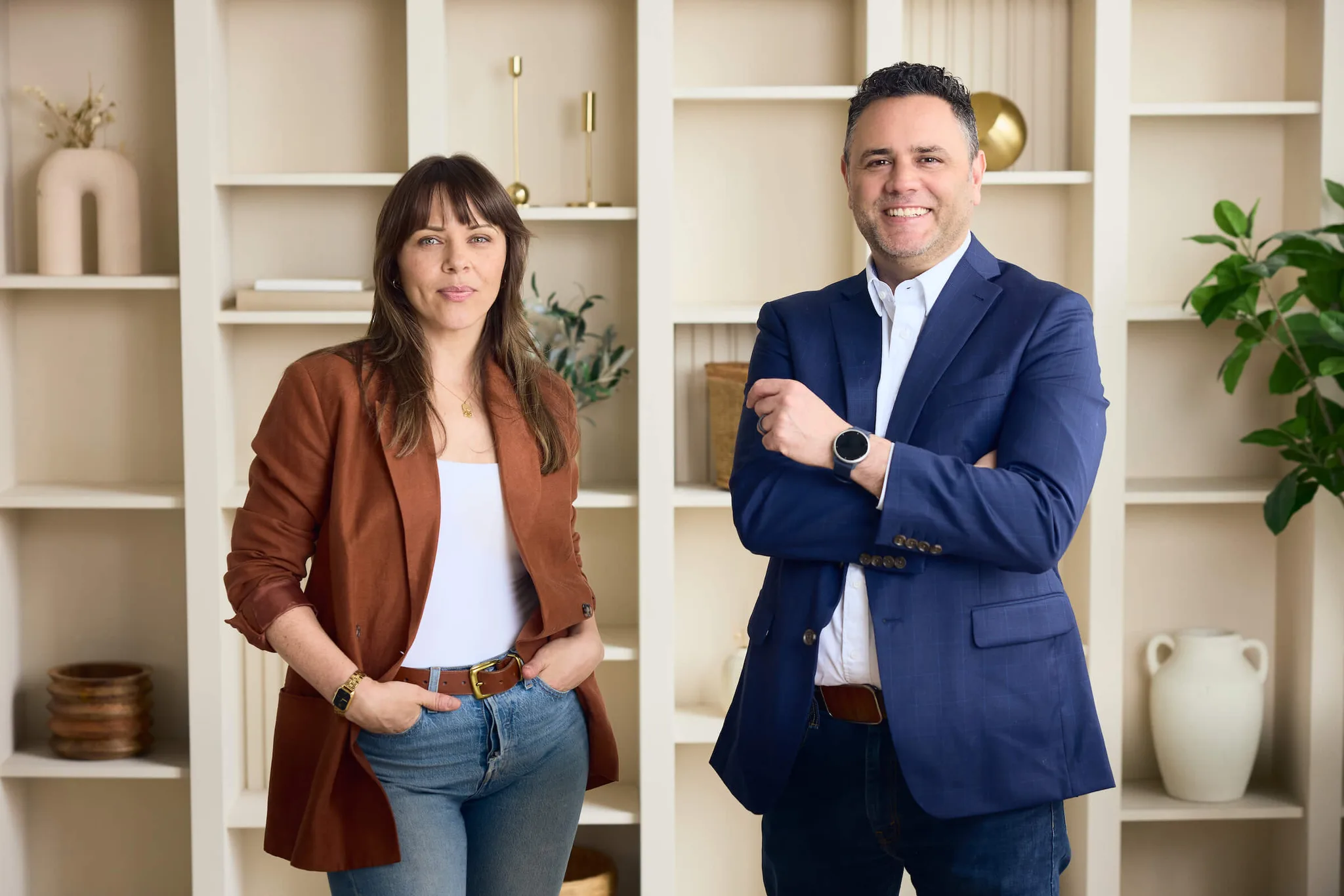Two professionals posing in a modern office space.
