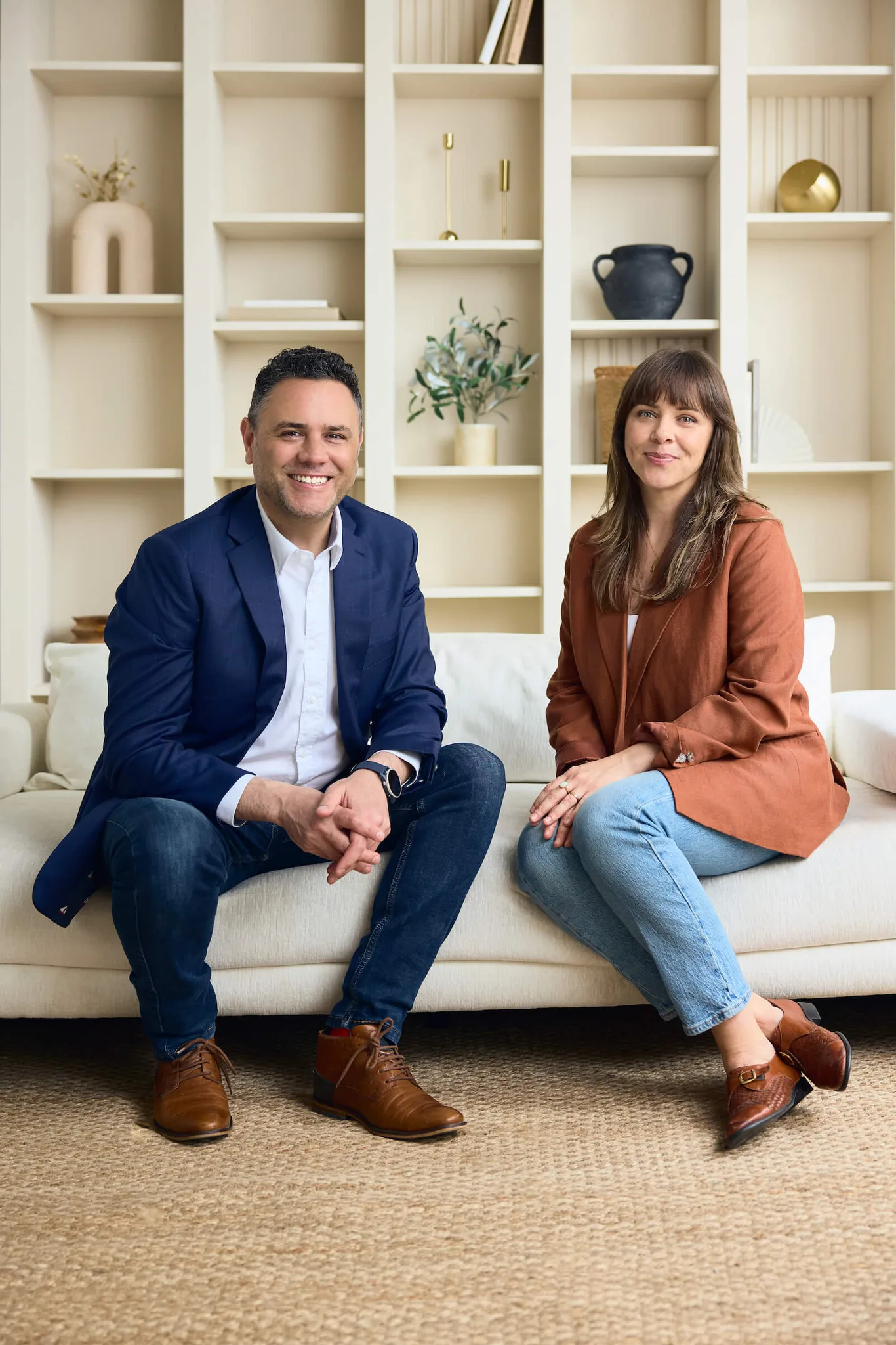 Two professionals sitting on a sofa in a modern room.