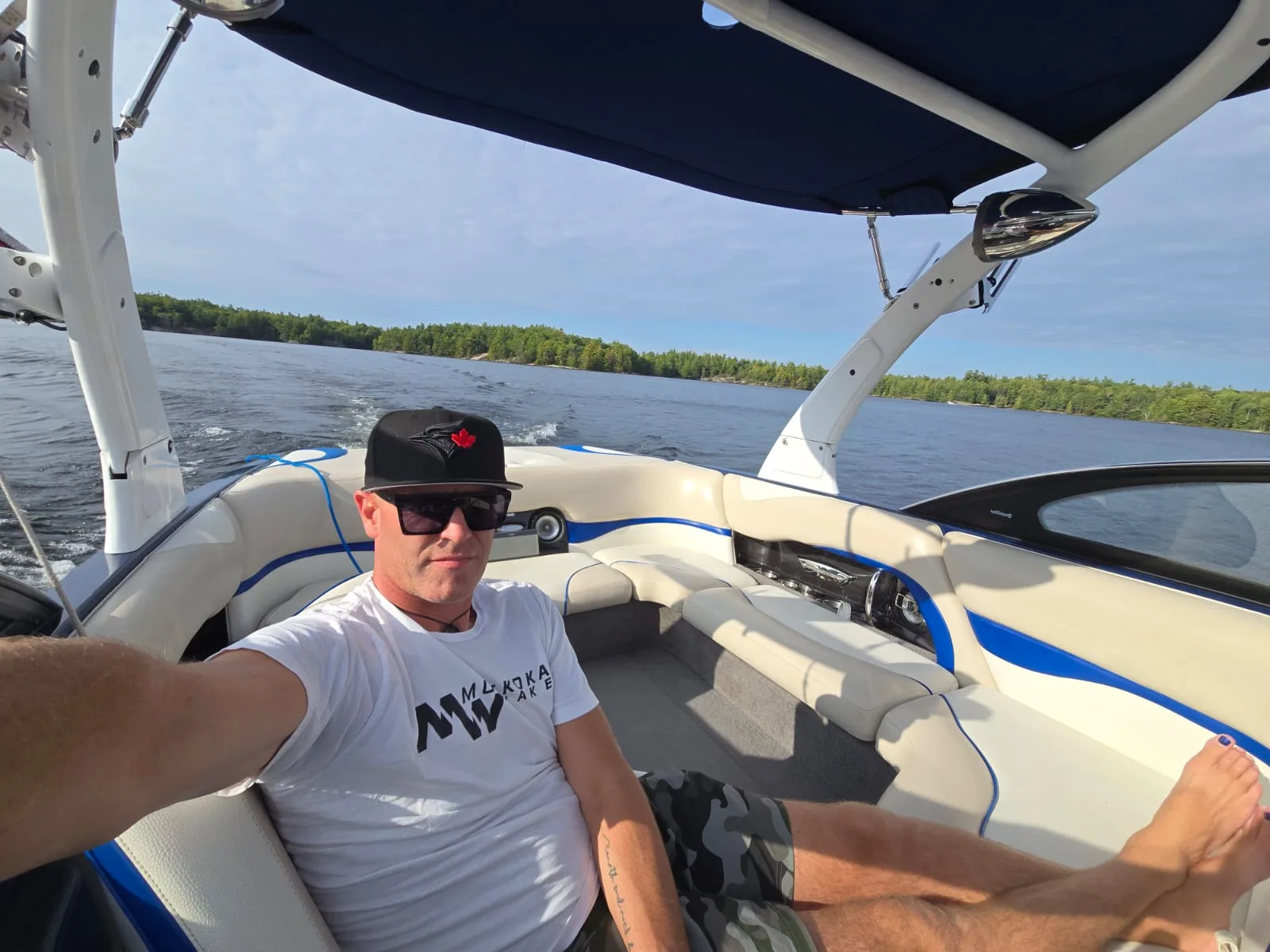 A man relaxing on a boat near a lake.