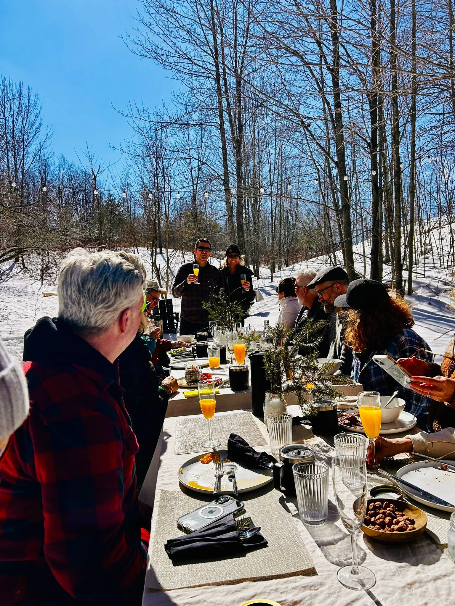 Guests enjoying brunch in a snowy forest setting.