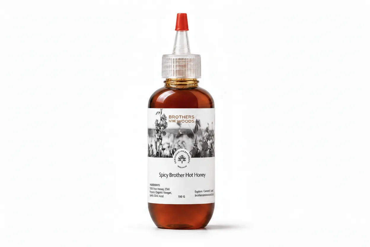Spicy Brother Hot Honey in a clear bottle with a red cap.