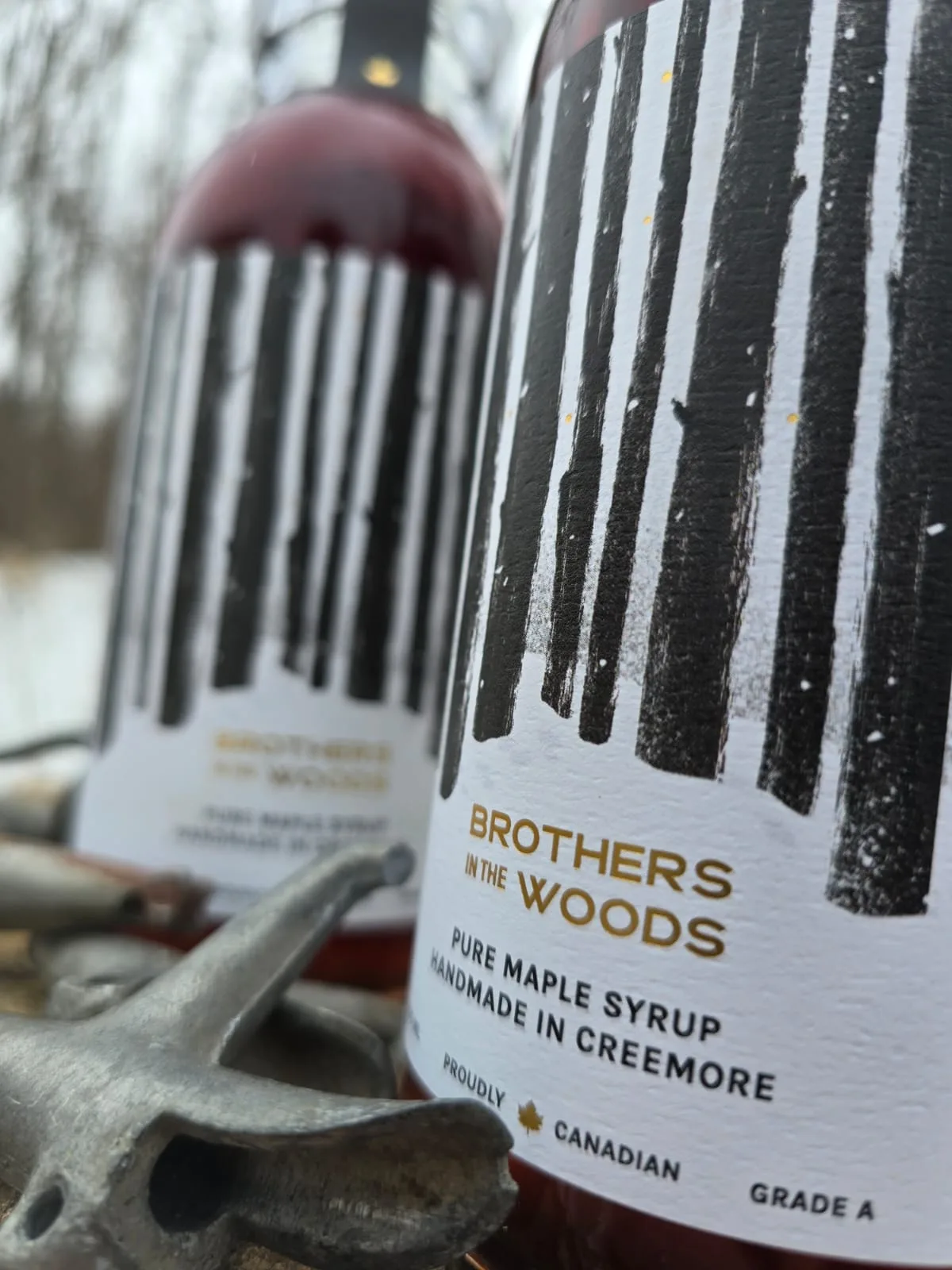 Two bottles of Brothers in the Woods maple syrup.