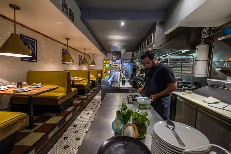 A chef preparing ingredients in a modern restaurant kitchen.