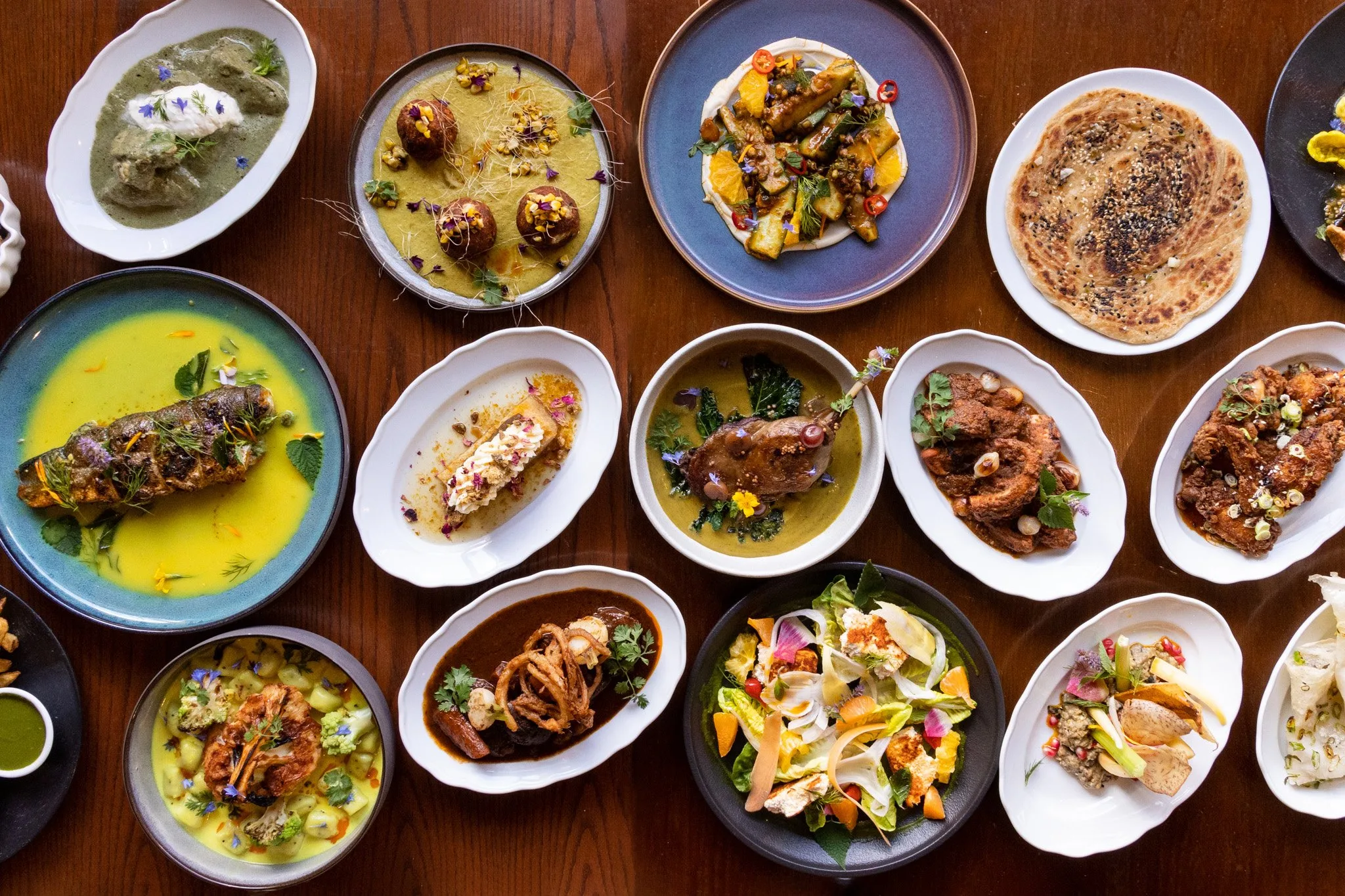 A variety of Indian dishes on a wooden table.