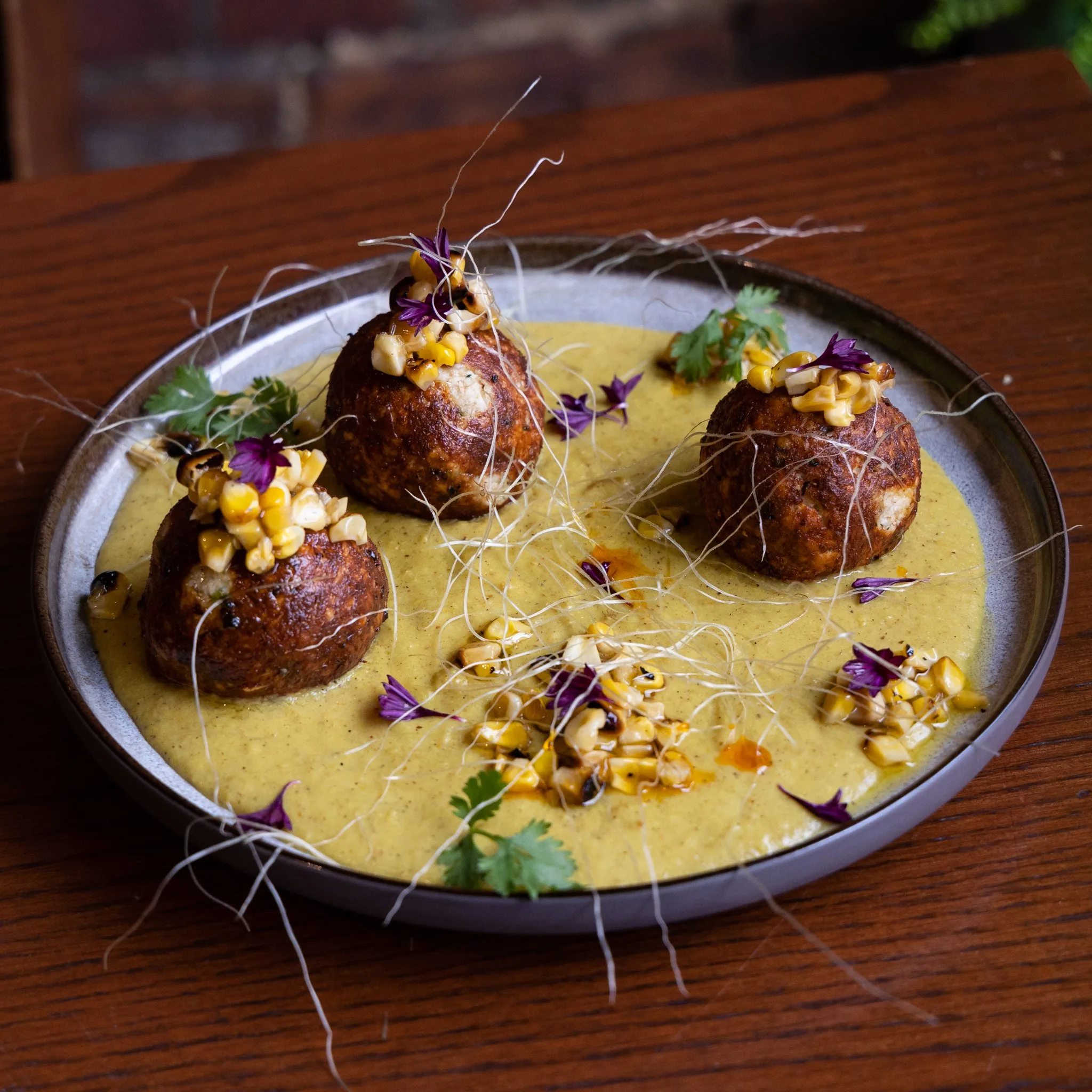 A plate of paani puri with sauce and garnishes.