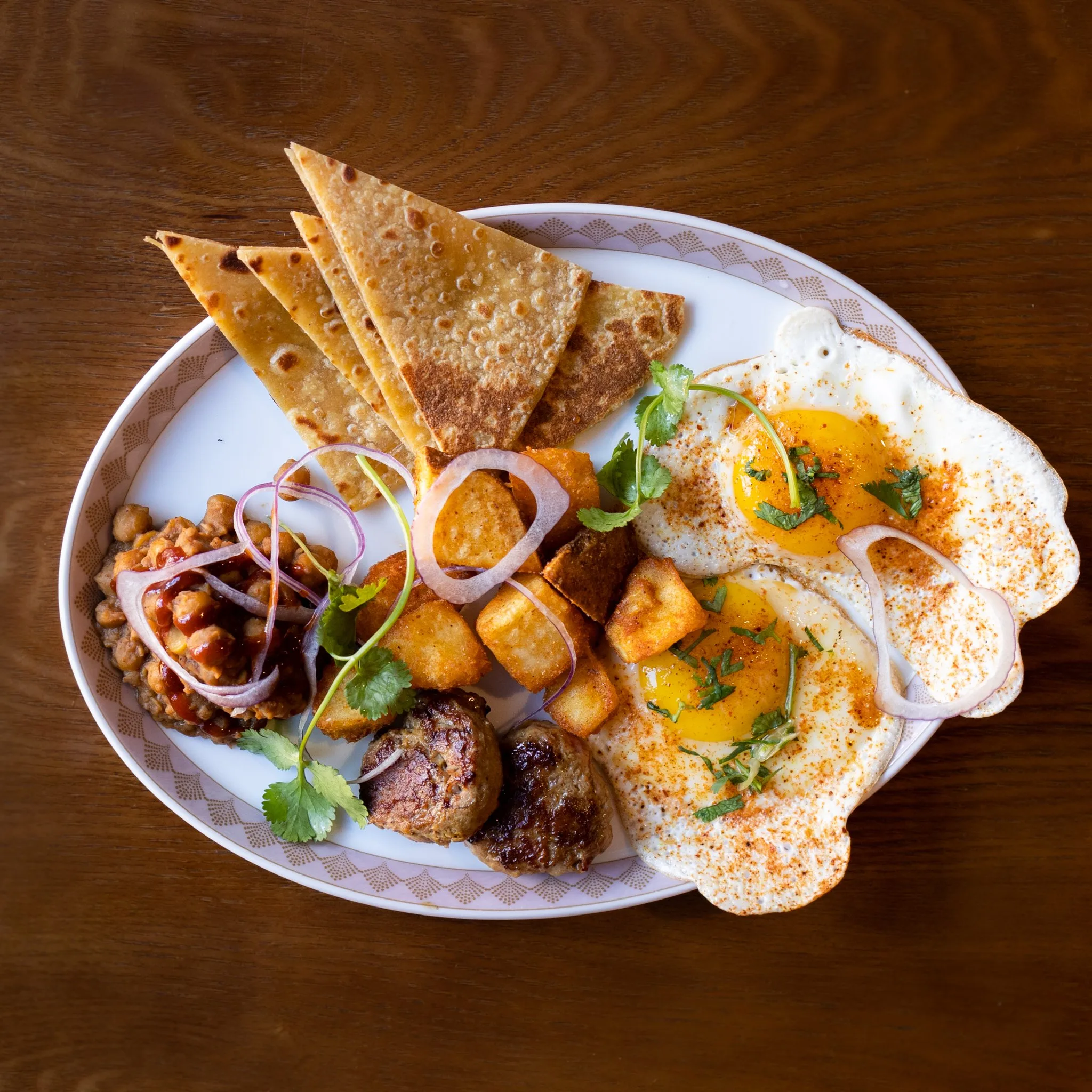 A vibrant Indian breakfast platter with eggs and flatbread.